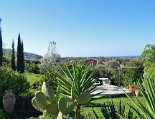 Blick von der Terrasse in den Garten und aufs Meer