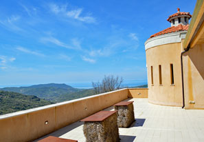 Blick von der Terrasse auf die grünen Hügel und das Meer